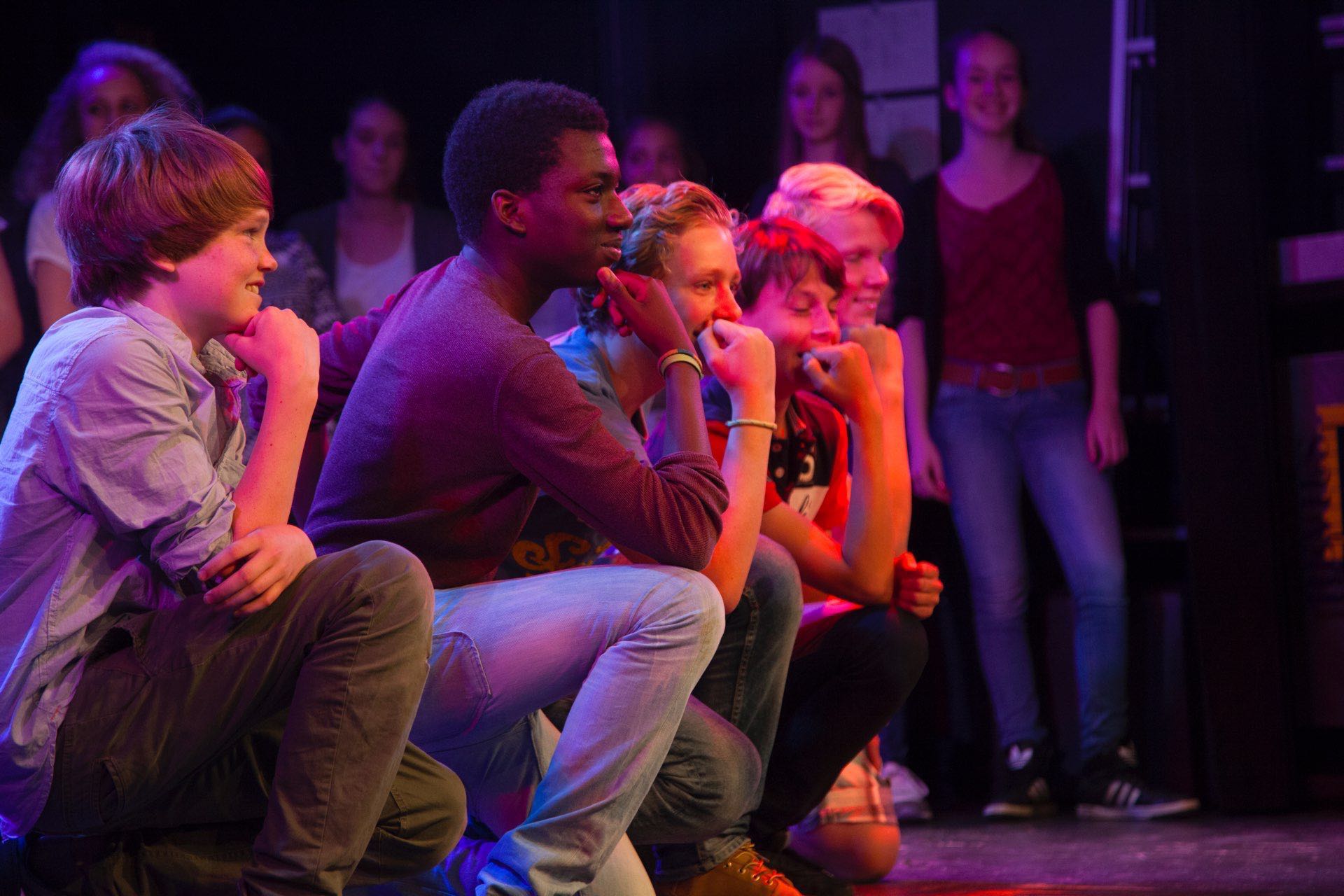 Leerlingen werken tijdens een theaterworkshop van TheaterChallenge samen op de vloer